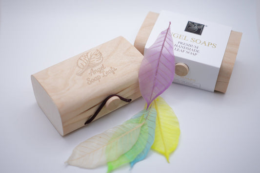 colorful leaves  soap with leaf design next to a wooden box and packaging 